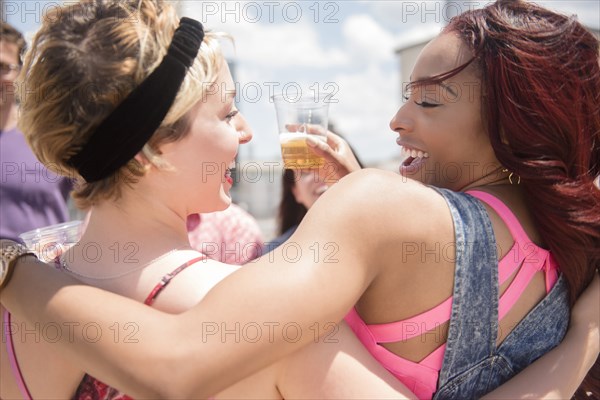 Smiling friends hugging outdoors