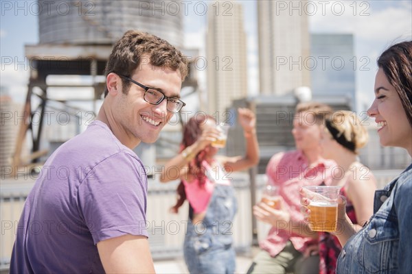 Smiling couple drinking beer outdoors