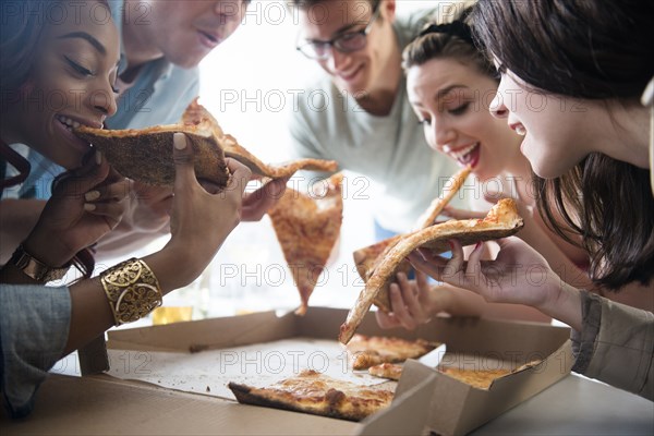 Friends eating slices of pizza