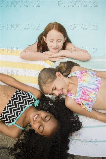 Smiling girls relaxing at swimming pool