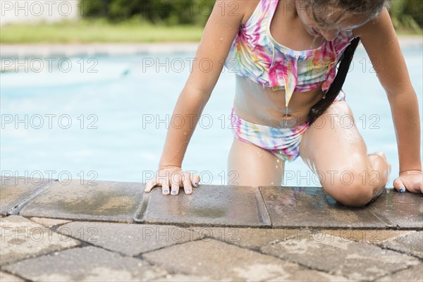 Caucasian girl exiting swimming pool