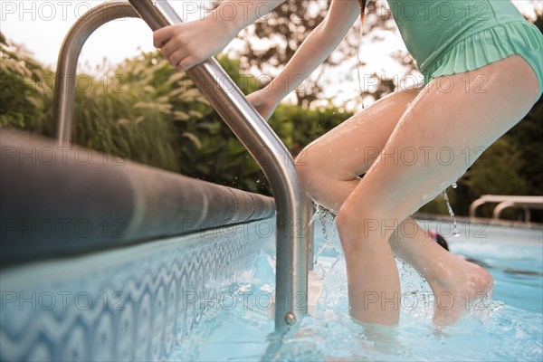 Caucasian girl exiting swimming pool