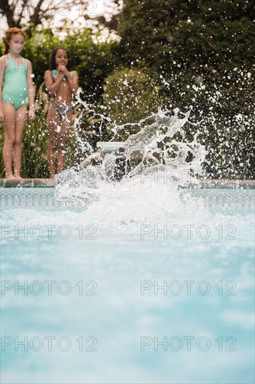 Splash from girl jumping into swimming pool