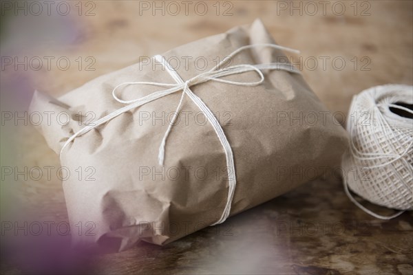 String tied around package wrapped in brown paper