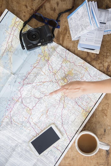 Finger of Caucasian woman pointing at map