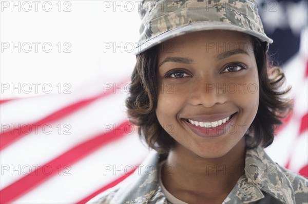 Portrait of smiling Mixed Race soldier near American flag