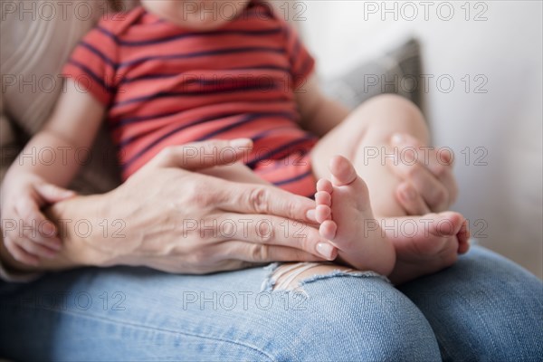 Caucasian mother holding baby son in lap