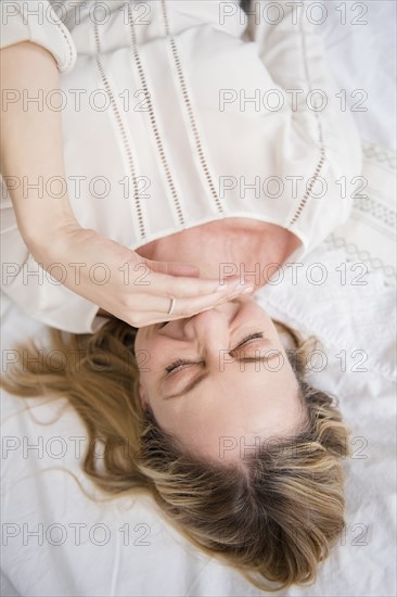 Laughing Caucasian woman laying on bed