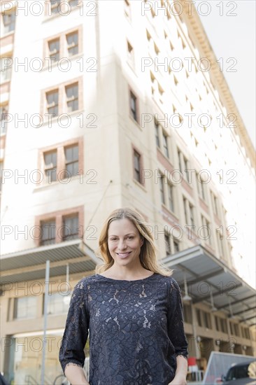 Portrait of smiling Caucasian woman standing in city
