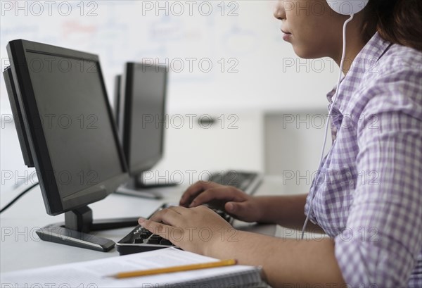 Hispanic woman typing in computer lab