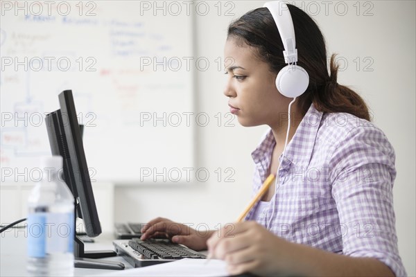 Hispanic woman typing in computer lab