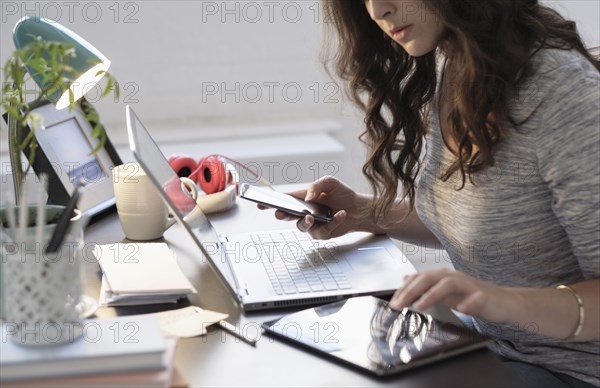 Hispanic businesswoman using technology in office