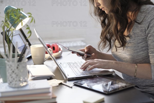 Hispanic businesswoman using technology in office