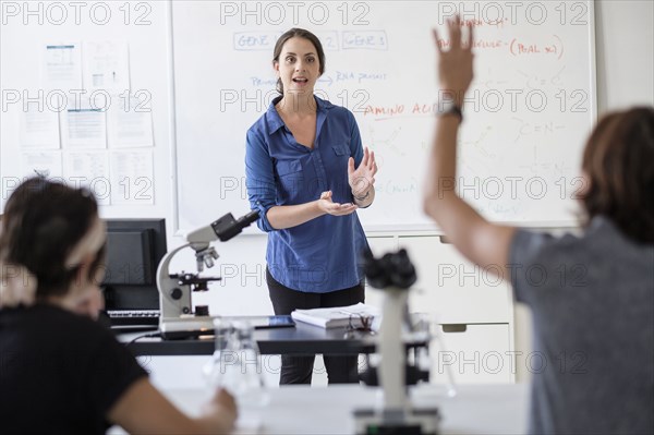 Students questioning professor in classroom