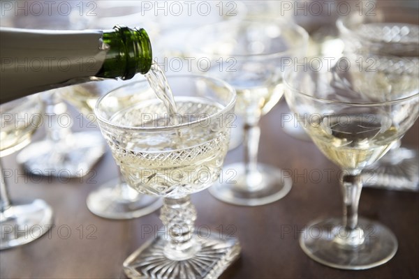 Champagne pouring from bottle into coupe