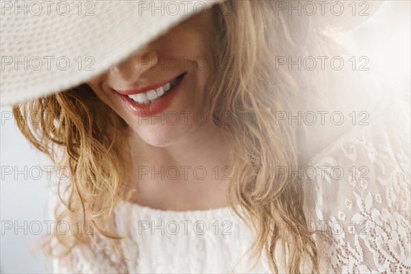 Sun hat covering face of Caucasian woman