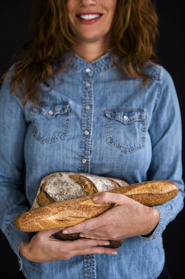 Smiling Caucasian woman holding bread