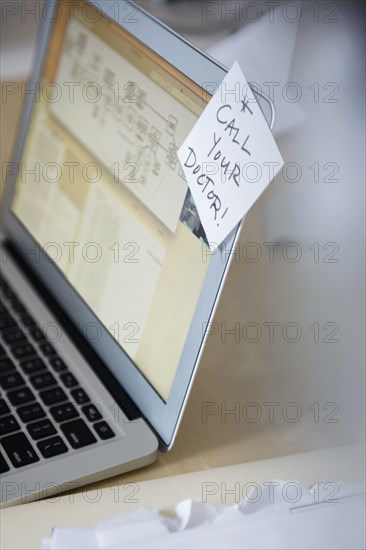 Reminder on adhesive note attached to laptop