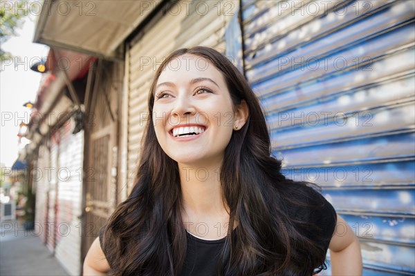 Smiling Thai woman standing on city sidewalk