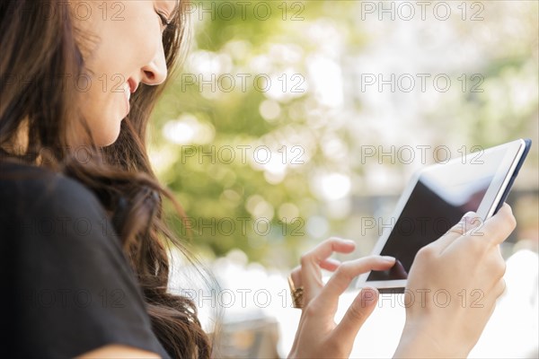 Smiling Thai woman using digital tablet