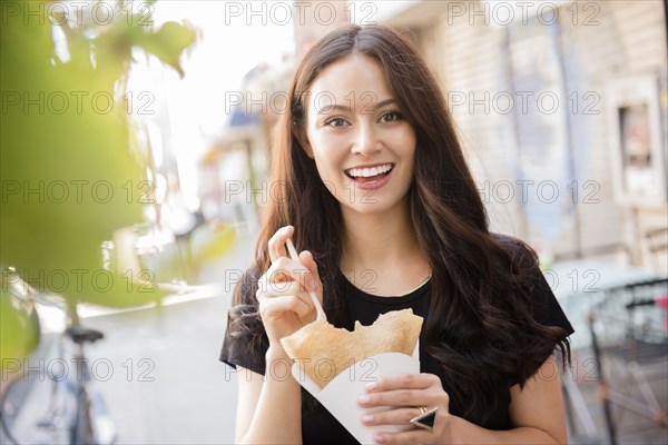 Thai woman eating food in city