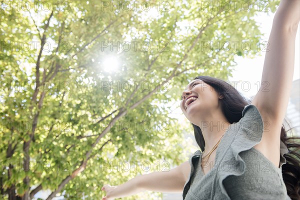 Thai woman celebrating under tree