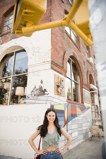 Smiling Thai woman posing on city sidewalk