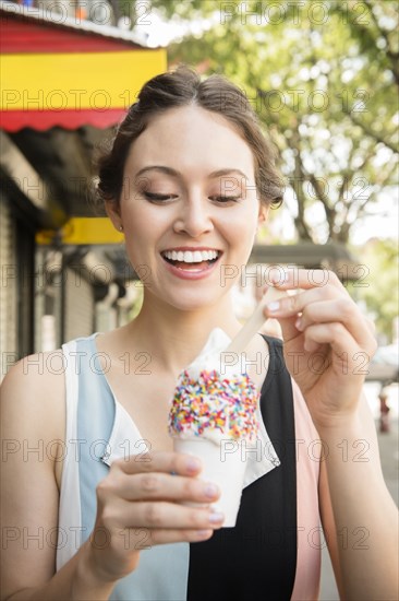 Thai woman eating ice cream in city