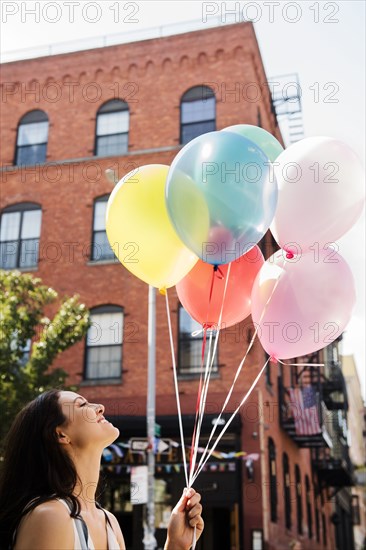 Thai woman holding balloons in city