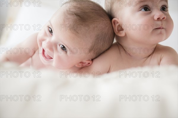 Caucasian twin baby girls laying on bed