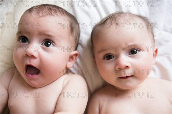 Surprised faces of Caucasian twin baby girls
