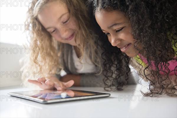 Smiling girls using digital tablet