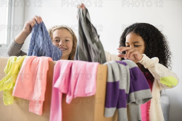 Girls examining box of clothing