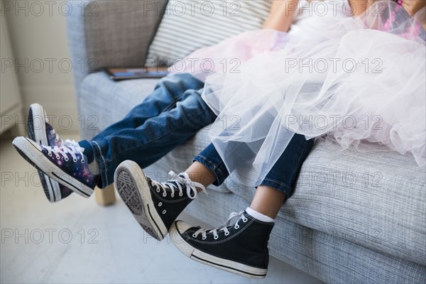 Legs of girls wearing tutus on sofa