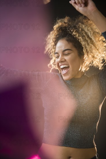 Mixed Race woman wearing sweater dancing