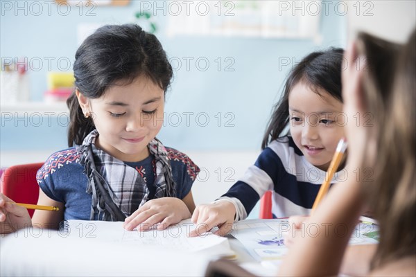 Girls reading notebook in classroom