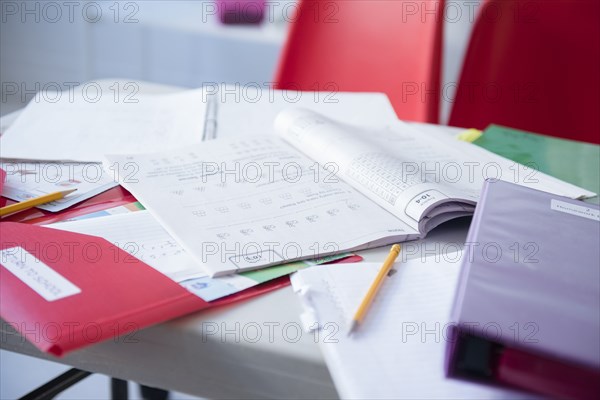 Workbook and folder on desk in classroom