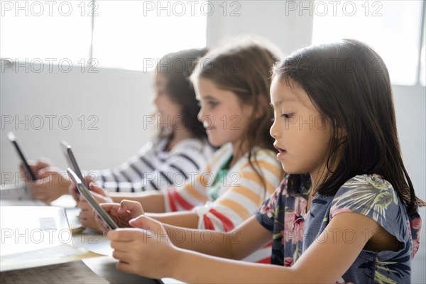 Girls using digital tablets in classroom