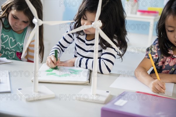 Girls learning about windmills and recycling in classroom