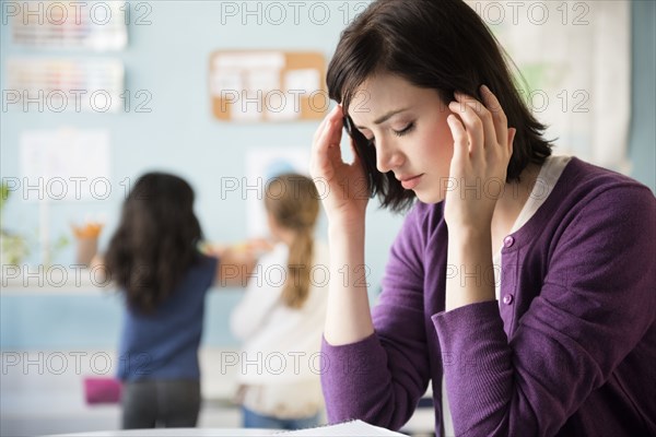 Caucasian teacher with headache in classroom