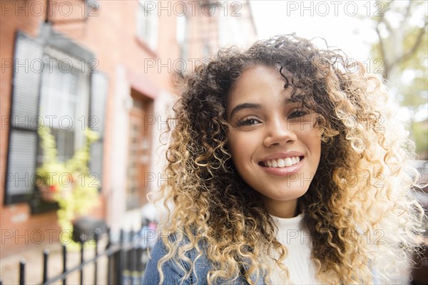 Smiling Mixed Race woman in city