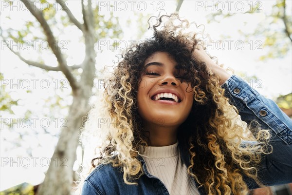 Smiling Mixed Race woman with hand in hair