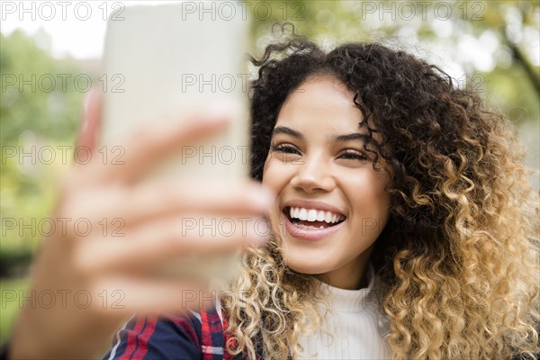 Mixed Race woman posing for cell phone selfie