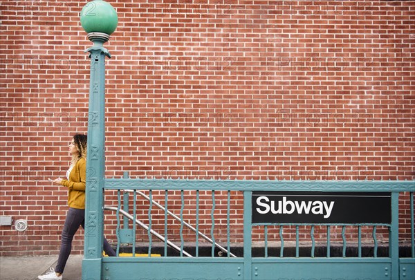 Mixed Race woman exiting subway station in city