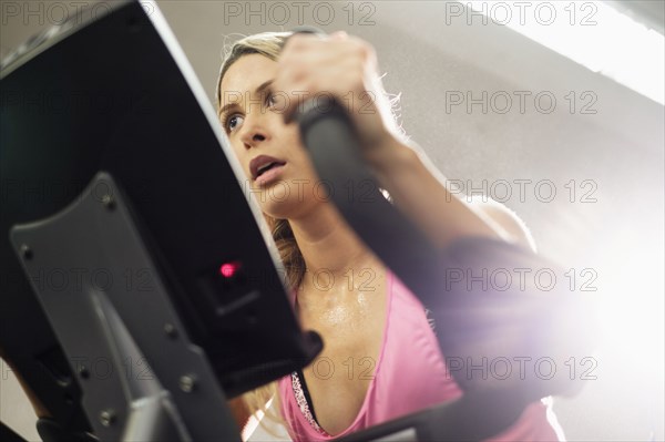 Mixed Race woman riding stationary bicycle