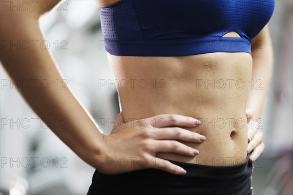 Sweating midriff of Mixed Race woman