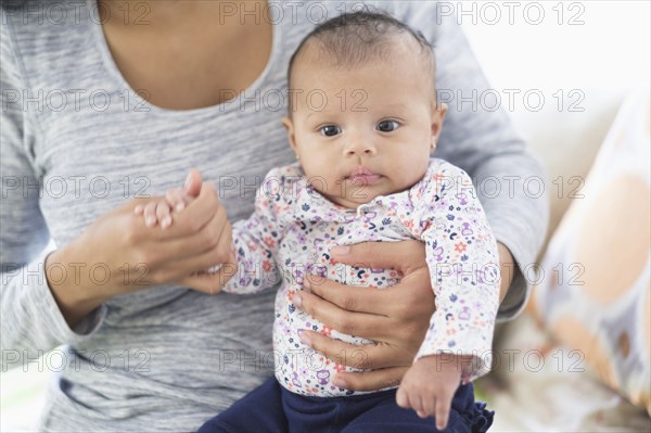 Hispanic mother holding baby daughter