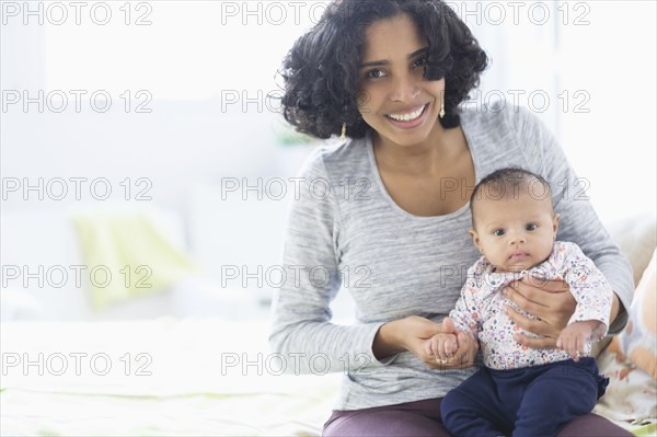 Hispanic mother posing with baby daughter