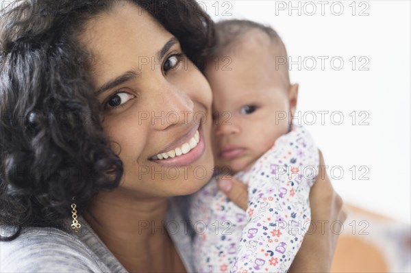 Hispanic mother posing with baby daughter