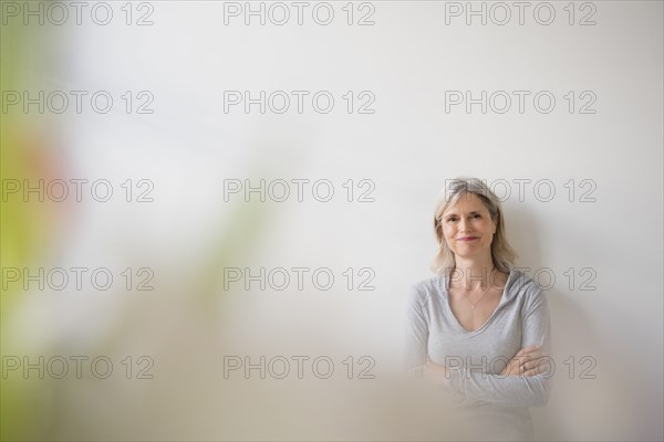 Smiling Caucasian woman leaning on wall